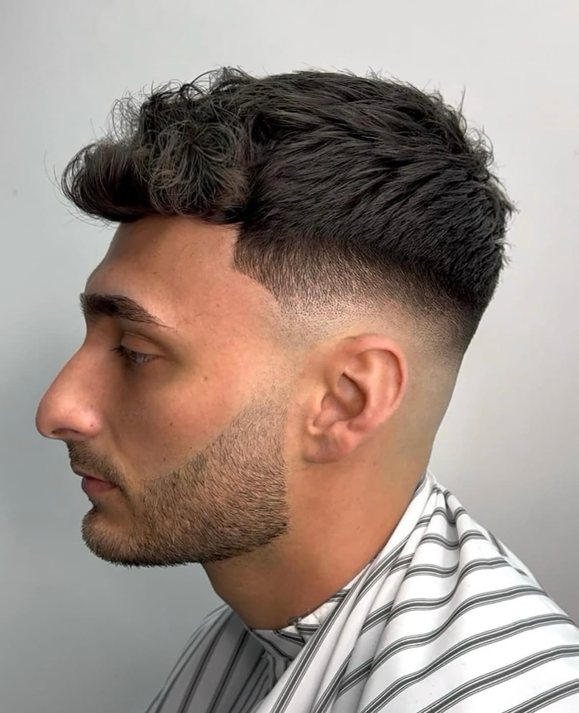 Dark textured quiff with a mid drop fade and a shaped, tapered beard